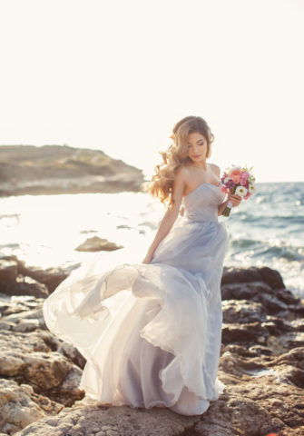 Bride in ball gown wedding dress near the sea
