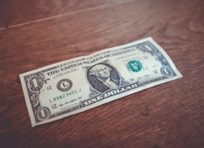 a 1 dollar bill on a wooden table