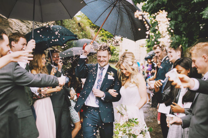 bride and groom exiting wedding as guests throw rice