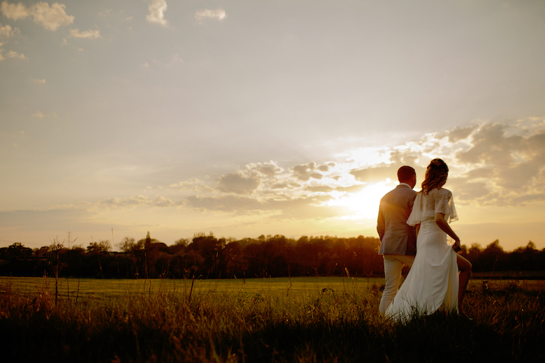 newly married couple stroll into the sunset