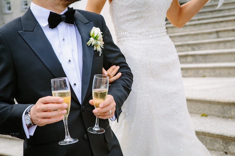 Groom holding two glasses of champagne