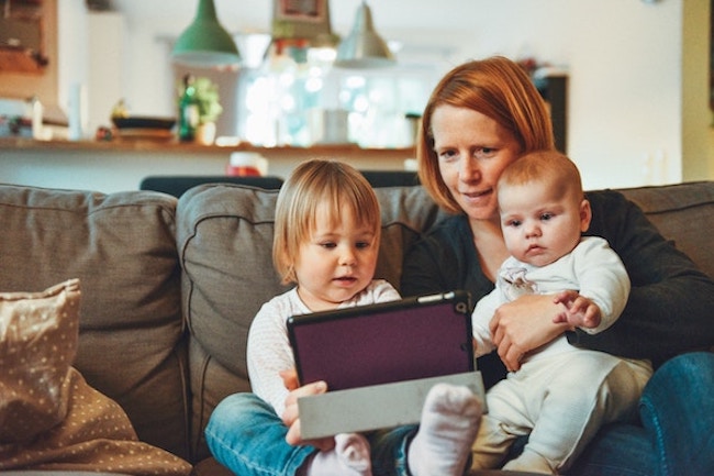 young mother with two of her children looking at a tablet device