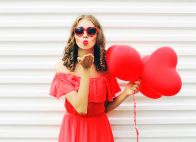 Woman wearing red dress gives air kiss