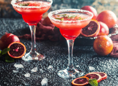citrus forward cocktail, pink with slices of blood orange/citrus