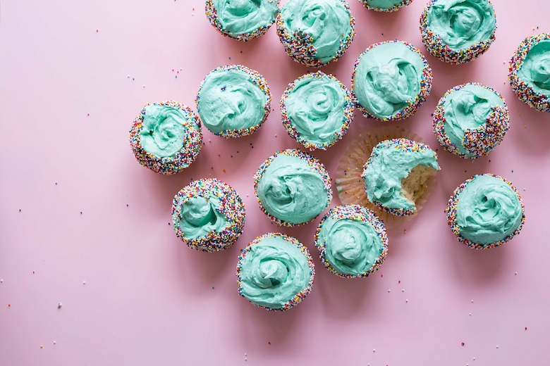 a bunch of blue frosting, sprinkle cupcakes
