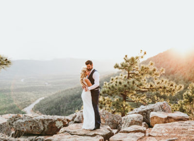Bride and groom embrace on a mountain