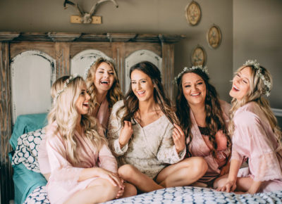 Bride and bridesmaid on bed laughing