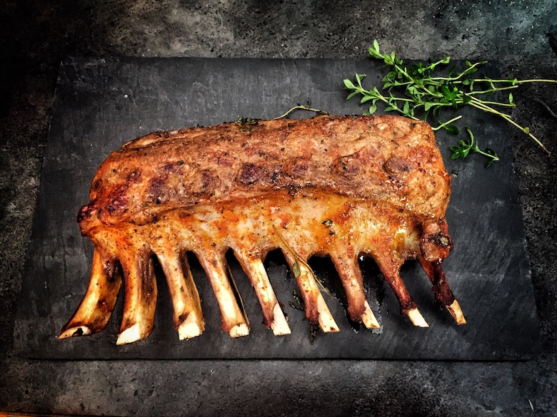 a beutiful rack of lamb served on a stone slab