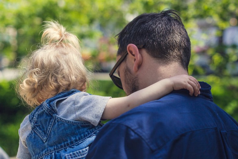 kind man holding his young toddler close