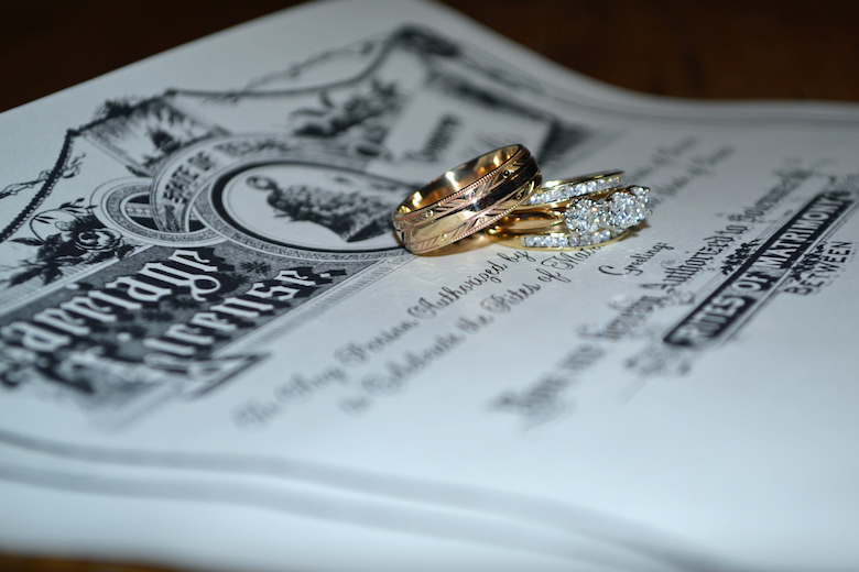 Marriage license with bride & groom wedding rings