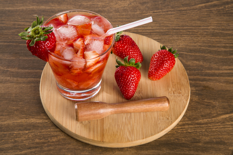 strawberry-based cocktail on a wooden plate