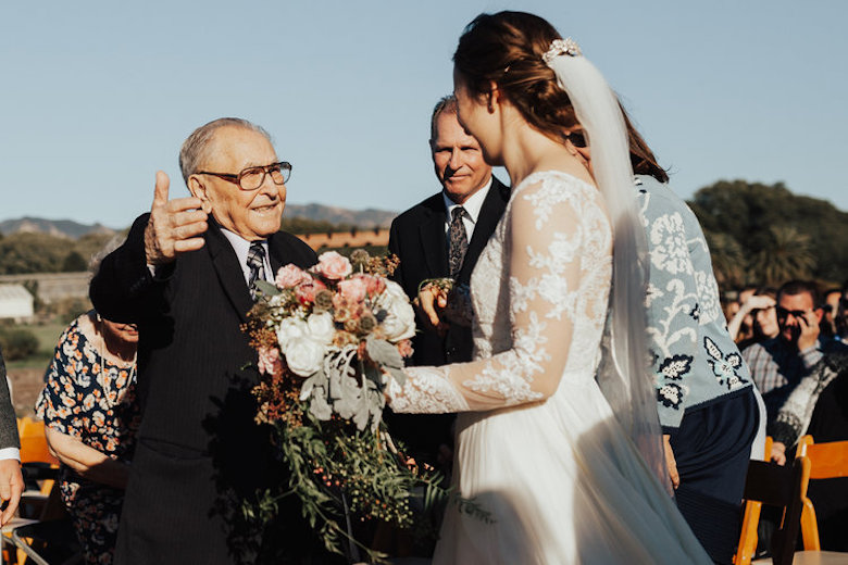 bride and grandfather prepare for an embrace, outdoor wedding