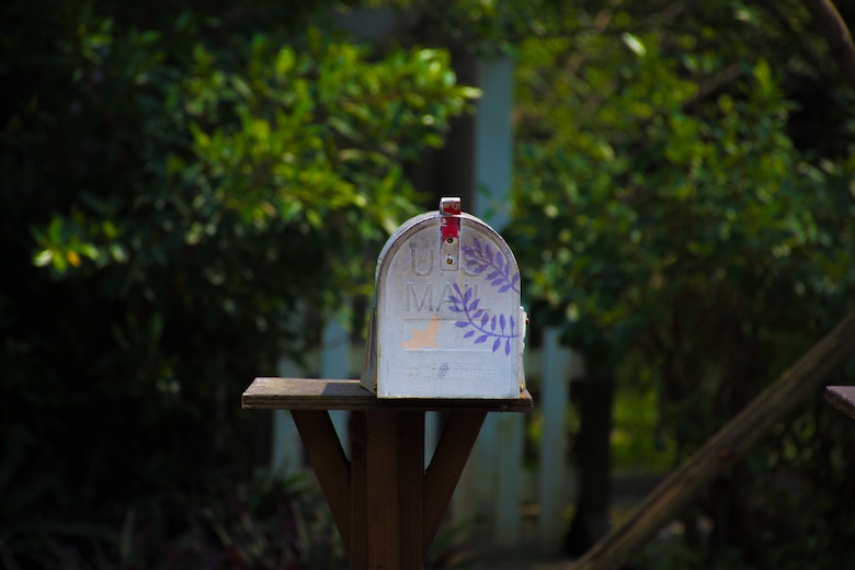 colorful traditional mailbox, trees in the background