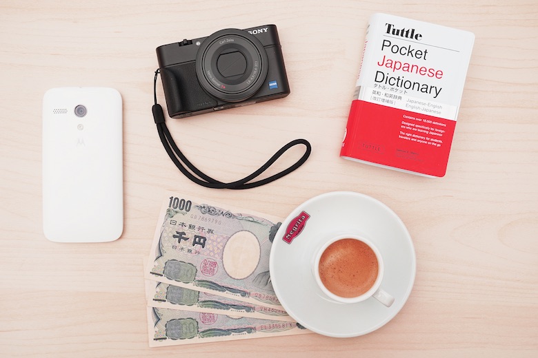 Travel kit for Japan, which includes a camera, a Japanese dictionary, some yen notes, a phone and a language CD