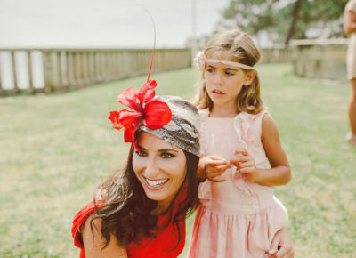 young woman in a red dress with her daughter at an outdoor wedding