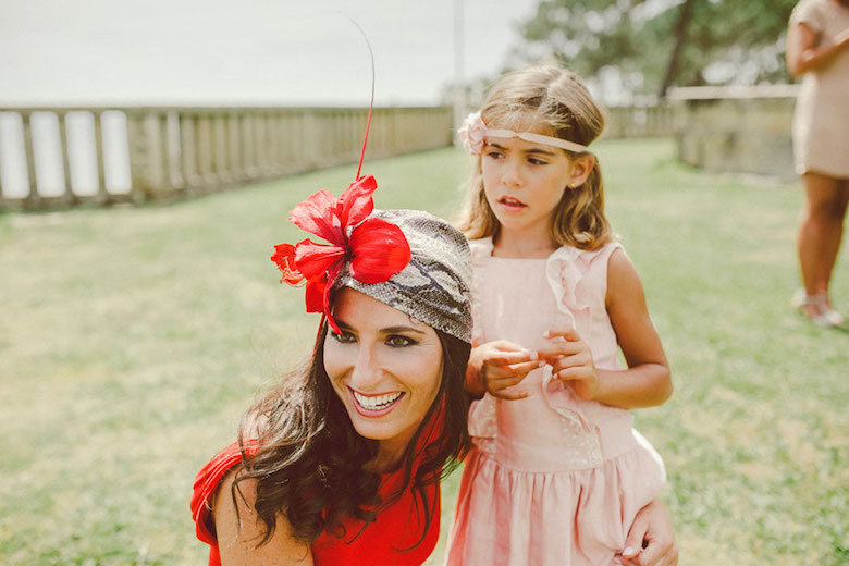 young woman in a red dress with her daughter at an outdoor wedding