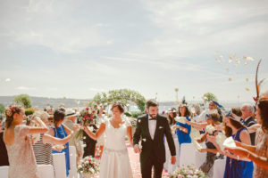 bride and groom walk through an arch