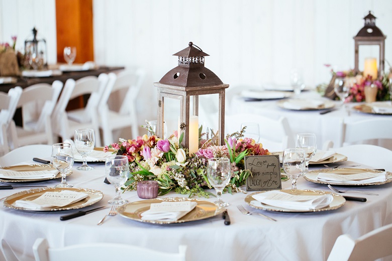 glass sided lantern vintage wedding centerpiece surrounded by flowers