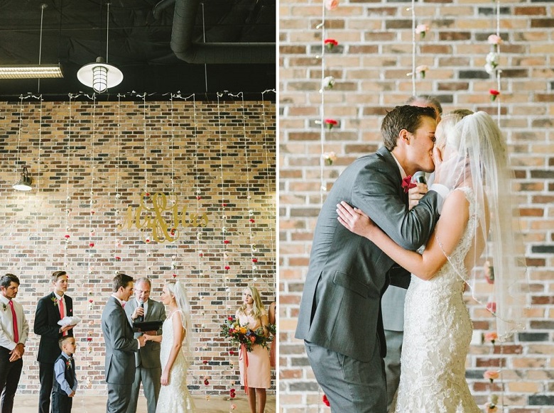 brick wall with dangling rope lights and bright colored florets