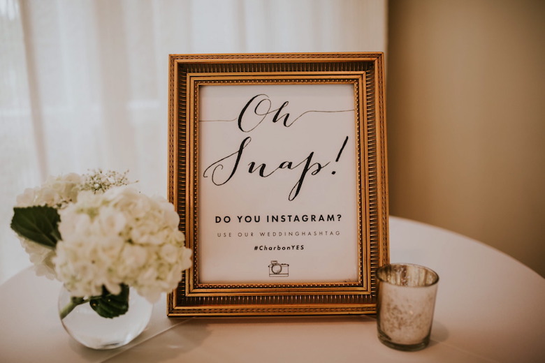 photo frame at a wedding that directs guests to connect their photos with a wedding Instagram hashtag
