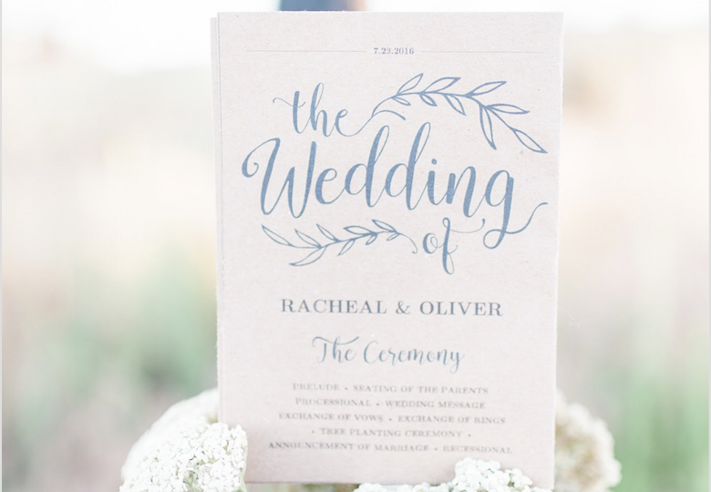 paper wedding schedule placed atop a bouquet of flowers