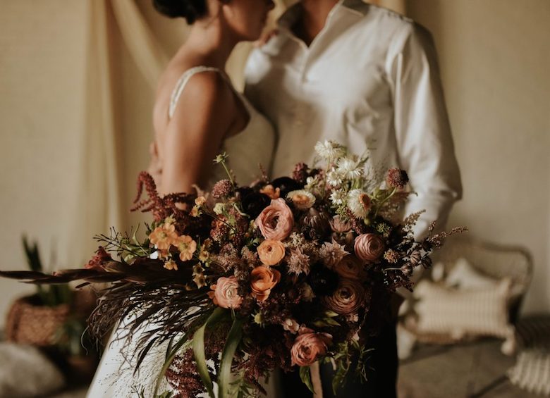 bride and groom with a wild flower bouquet
