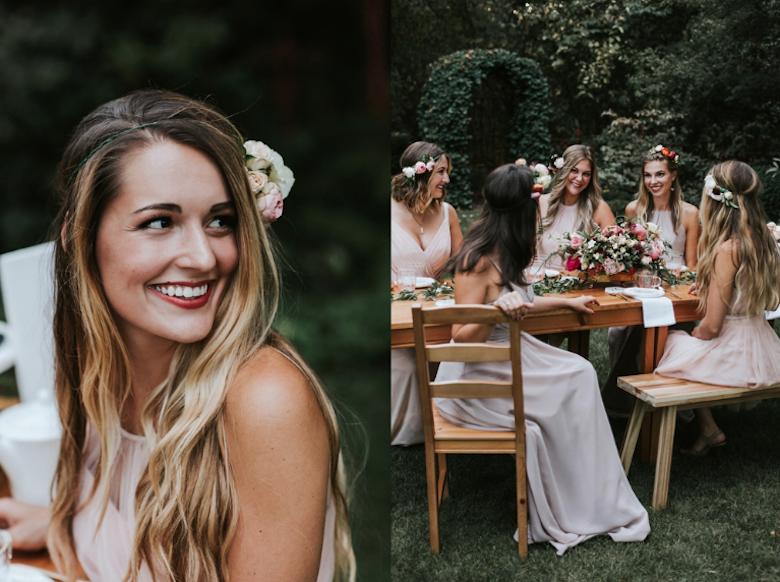 smiling bride and bridesmaids sitting at an outdoor table in a green garden