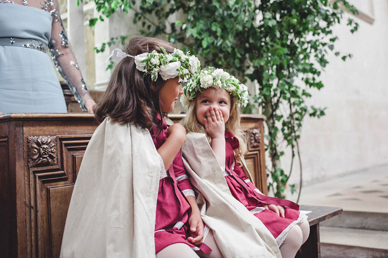 flower girls in pink giggling during wedding ceremony