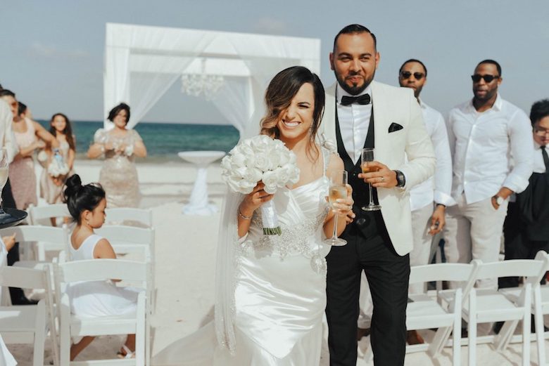 bride and groom walk down the aisle at beach wedding