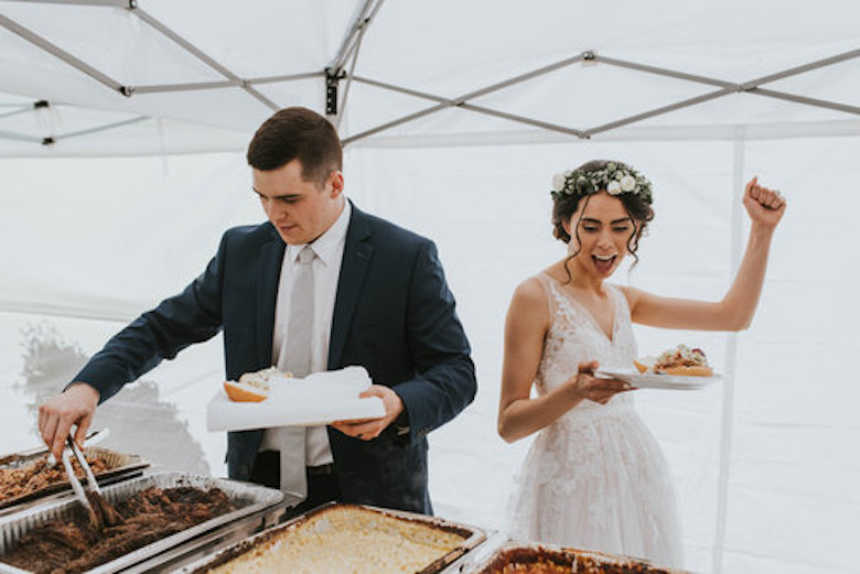 bride and groom eat food catering at wedding