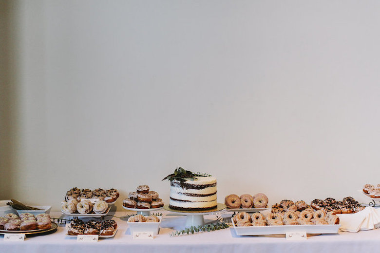 table with sweets, donuts, and wedding cake 