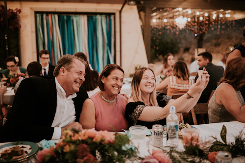 happy wedding guests take a selfie, indoor event