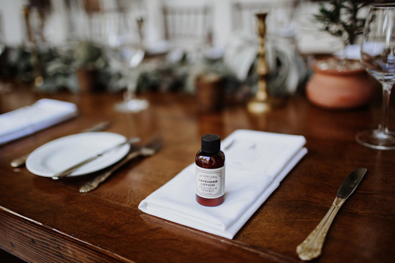 wedding table setup, lavender lotion favors and menu placed on ornate wooden table