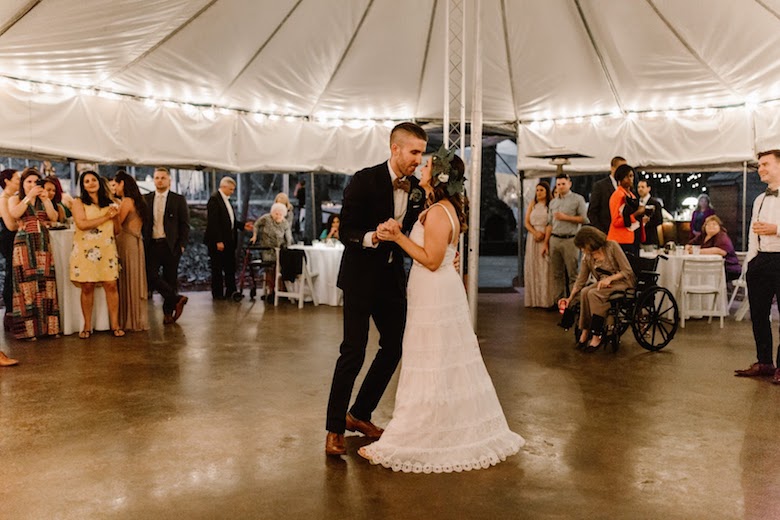 bride and groom's first dance under wedding tent