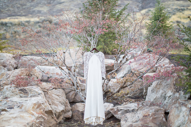 wedding gown hanging under cherry blossom tree