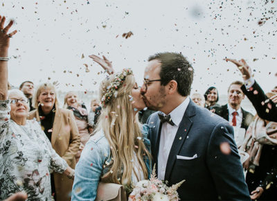 bride and groom kissing under confetti poppers for spring wedding's grand exit