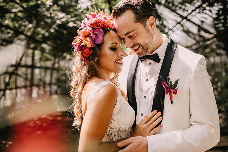 bride wearing a a fresh spring flower crown. groom wearing a white tux and a floral boutonniere