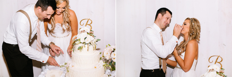 bride and groom trying their white tiered wedding cake with floral topper