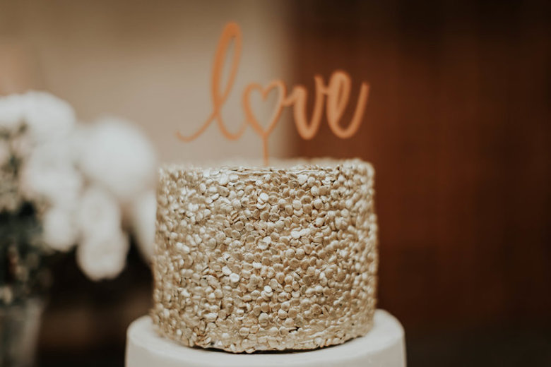 the word love topping a wedding cake