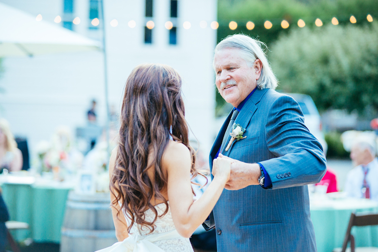 father and daughter dancing at an outdoor wedding, lovely lights and decor in the background