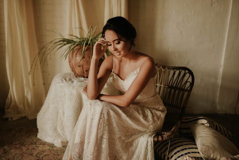 bride sitting down in a chair in an informal wedding dress