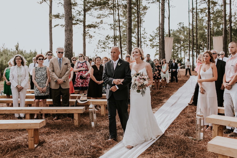 father walking bride down the aisle at outdoor wedding