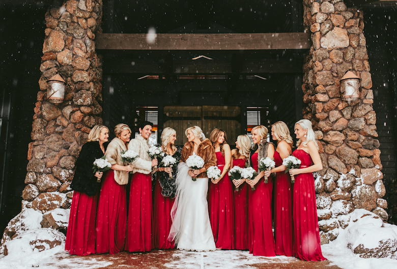 winter bride surrounded by bridesmaids robed in red