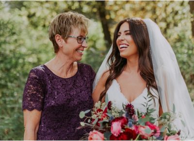 mother and bride laughing with bouquet