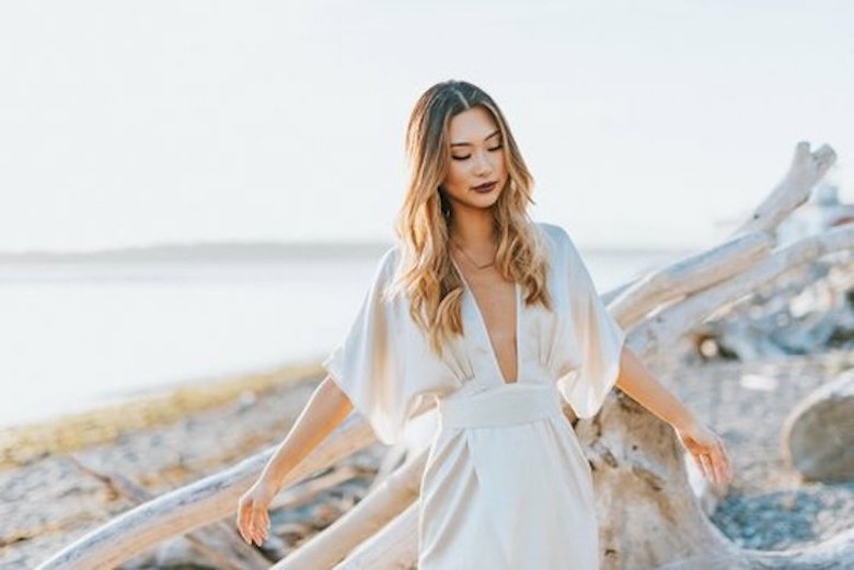 bride wearing a jumpsuit wedding gown at the beach