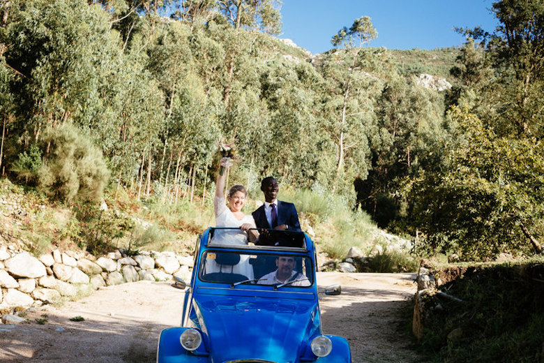 bride and groom riding off in a beetle car