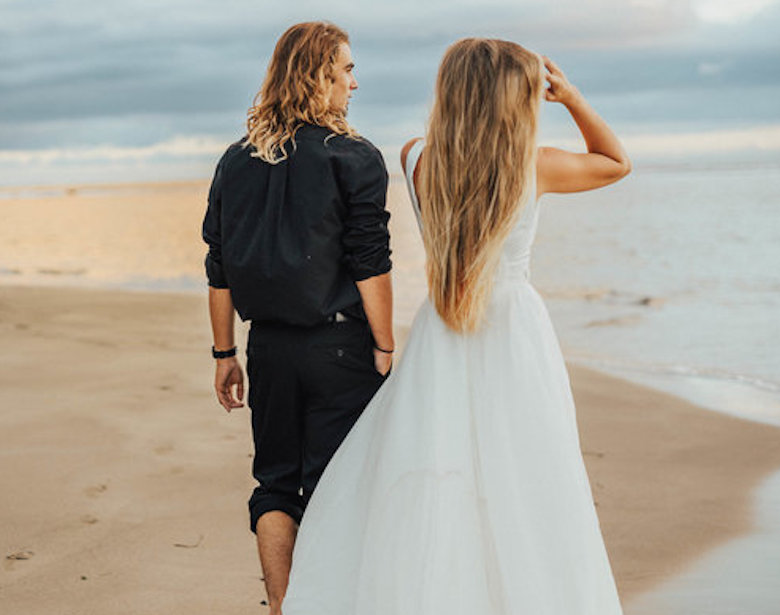 bride and groom walking by the beach