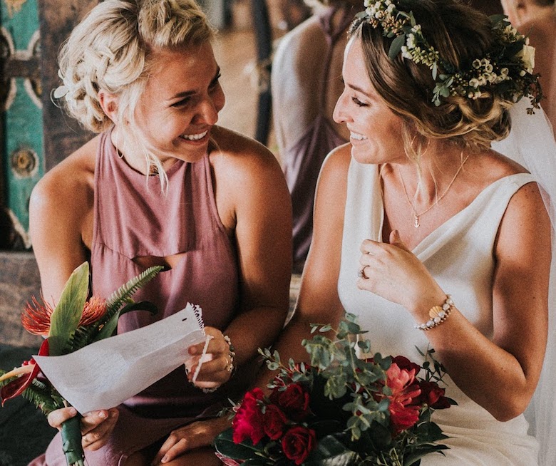 bride and maid of honor reading wedding favor letter