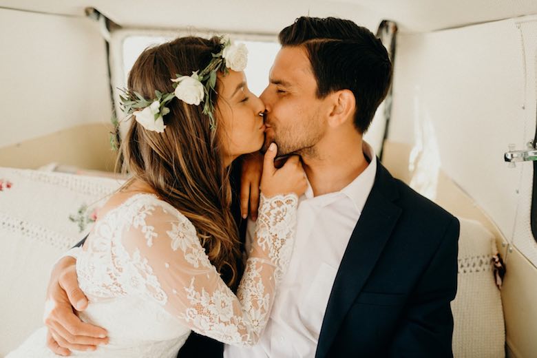 bride kissing groom inside a carriage