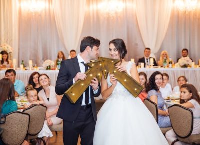 bride and groom holding arrows during a wedding reception game